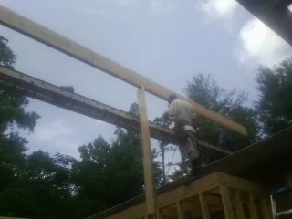 Carpenter setting a ridge beam over a new addition frame — Ice Dam Removal by Roofing Brothers in Woodward